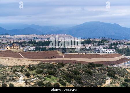 Häuser auf einem Hügel mit Blick auf das San Fernando Valley im Porter Ranch-Viertel von Los Angeles, Kalifornien. Die San Gabriel Mountains und Angeles Stockfoto