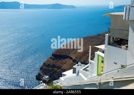 Fira, Griechenland - 19. Juli 2019: Blick über die Klippe von Fira hinunter zur ägeischen See Stockfoto