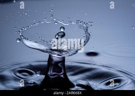 Wassertropfen Zusammenstoß auf einem blauen Hintergrund. Abstrakte klare Natur Hintergrund Stockfoto