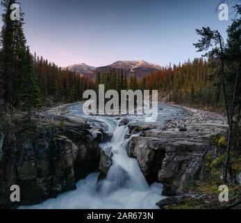 Sunwapta Falls ist ein Paar des Flusses Sunwapta im Herbstwald bei Sonnenuntergang. Icefields Parkway, Jasper Nationalpark Stockfoto