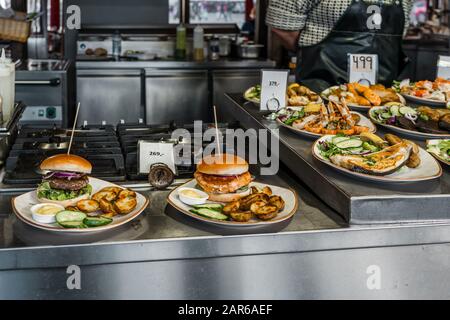 Speisen für den Verkauf auf dem Bergen Fish Market, mit Fertiggerichten wie Hamburger und Fisch Stockfoto