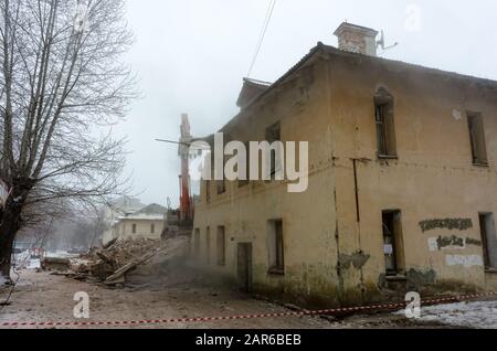 Abriss eines Hauses mit einem orange digger Stockfoto