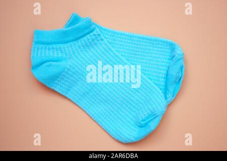 Blaue Socken auf braunem Grund. Niedrige Sportsocken für Damen. Ein Paar Socken aus Baumwolle, Draufsicht. Stockfoto