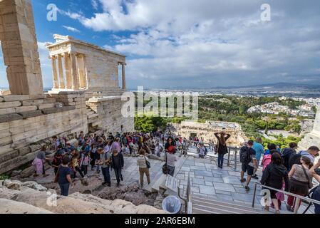 Touristen auf einer Treppe vor Gateway genannt Propyläen, Eingang an der Spitze der Akropolis von Athen, Griechenland. Tempel der Athena Nike links Stockfoto