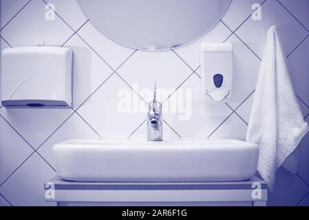 Weißes Waschbecken mit Handtuch und Seife im Spa-Salon. Stockfoto