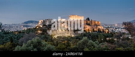 Panoramablick auf den Akropolishügel bei Nacht, Athen, Griechenland. Die berühmte alte Akropolis ist ein Wahrzeichen Athens. Antike griechische Ruinen im Zentrum von Athen Stockfoto