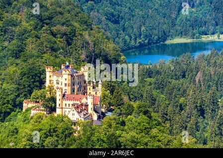 Schloss Hohenschwangau bei Füssen, Bayern, Deutschland. Diese wunderschöne Burg ist ein Wahrzeichen der deutschen Alpen. Luftbild mit Blick auf Schloss und Schwansee la Stockfoto