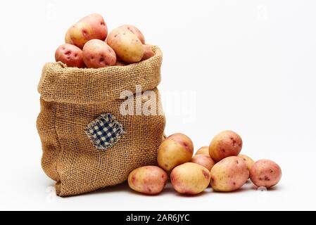 Beutel mit Kartoffeln auf weißem Grund. Stockfoto