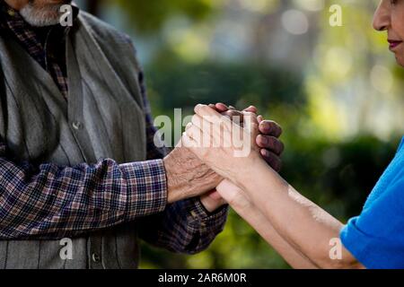 Glückliches älteres Paar, das die Hände im Park hält Stockfoto