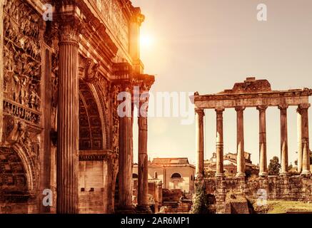 Bogen von Kaiser Septimius Severus und Saturntempel in der Ferne auf dem Forum Romanum. Rom, Italien. Stockfoto