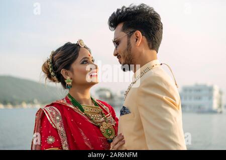 Porträt des jungen indianischen Paares, das in bunten Kleidern in der Nähe des Pichola-Sees in Udaipur, Rajasthan, Indien, verheiratet sein soll. Stockfoto