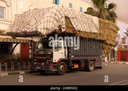 Ein LKW, der meisterhaft mit Heu in einer Straße in Tan Tan beladen ist Stockfoto