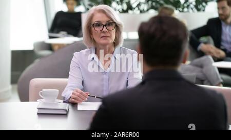 Ernsthafte Mittelalter-Frau-h-Managerin führt Interview mit der Bewerberin. Stockfoto