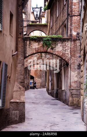 Die Bögen von Siena, bekannt für ihre roten Backsteine, sind eine Freude für die Wanderer dieser wunderbar erhaltenen gotisch-romanischen Stadt in der Toskana, Italien. Stockfoto