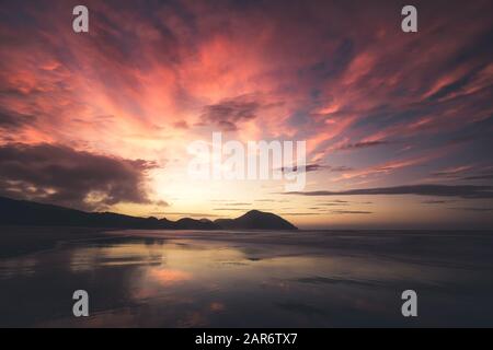 Sonnenaufgang am Strand von Wharariki, Neuseeland Stockfoto