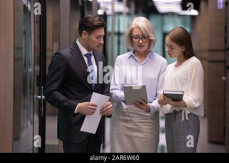 Konzentrierte Führungskraft mittleren Alters zeigt den Kollegen Projektergebnisse. Stockfoto
