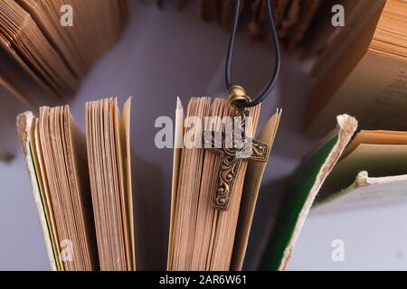 Dekoratives geknipptes Kreuz vor den bibelseiten. Stockfoto