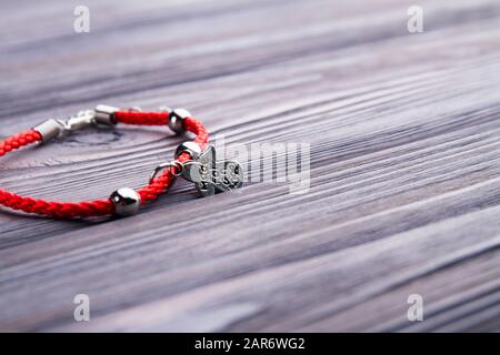 Rot dekoriertes Armband aus nächster Nähe auf Holz. Stockfoto