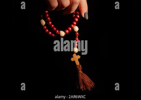 Nahaufnahme der Hand einer Frau, die Rosenkugeln hält. Stockfoto