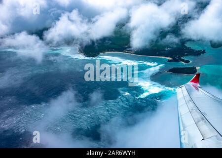 Ein Luftbild der Küste von Mauritius im Indischen Ozean, der die Flügelspitze und die Farben eines Air Mauritius-Flugzeugs zeigt. Stockfoto
