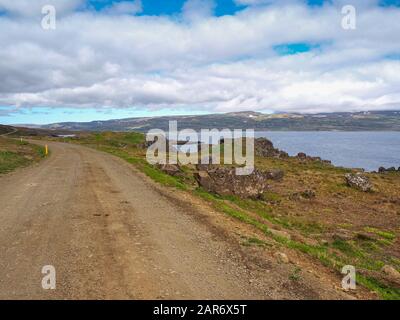 Leere Schotterstraße in der Nähe von Drangsnes in den Fjorden von Island Stockfoto