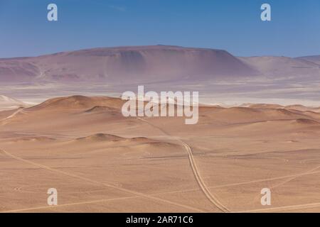 Paracas National Reserve, bunte Sande, Wüstenhügel, im Zentrum befindet sich eine Autobahn, Palisco, Peru. Stockfoto