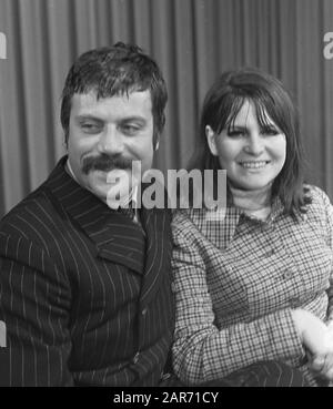 Filmschauspieler Oliver Reed mit Frau bei Schiphol Filmschauspieler Oliver Reed mit einer Frau auf Schiphol; Stockfoto