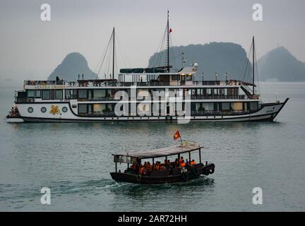 Touristen in Tender mit Kreuzfahrtschiff in Nebel in der Dämmerung, Halong Bay, Vietnam, Asien Stockfoto