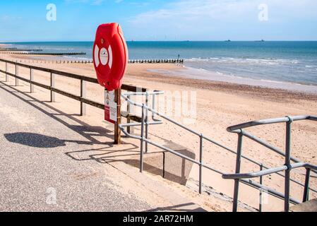 Lebensgürtel entlang eines eingezäunten Wegs und an den Stufen, die an einem klaren Frühlingstag zu einem sandigen Strand führen. Sicherheitskonzept. Stockfoto