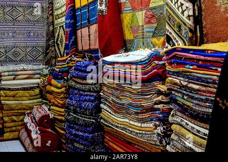 Marokkanische Teppiche mit lebhaften Farben, die in der schmalen Straße von Rabat in Marokko angeboten werden, mit selektivem Fokus. Marokko Stockfoto