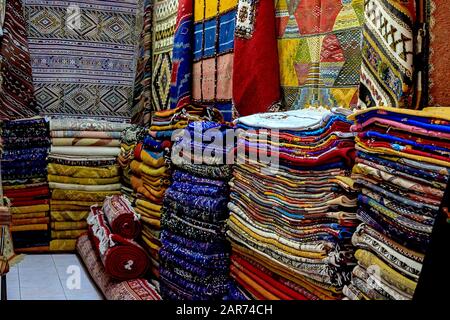 Marokkanische Teppiche mit lebhaften Farben, die in der schmalen Straße von Rabat in Marokko angeboten werden, mit selektivem Fokus. Marokko Stockfoto