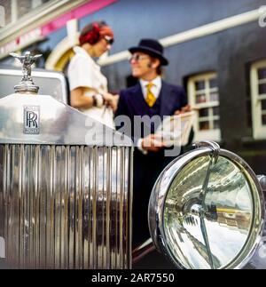 London 1970er Jahre, 1936 Rolls-Royce Kühlergrill, Scheinwerfer, Spirit of Ecstasy Statue, Kapuze Ornament, Maskottchen, verschwommenes elegantes Paar, England, UK, GB, Großbritannien, Stockfoto