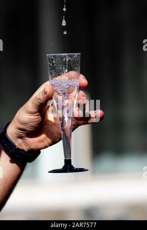 Herren Hände, die Sekt in ein Glas gießen, Nahaufnahme Stockfoto