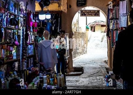 Fes, Marokko - 21.04.2019: Menschen, die in der Straße des Open-Air-Marktbasars in Fez spazieren. Traditionelle nordafrikanische Geschäfte mit handgefertigter Betubung Stockfoto