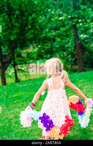 Wunderschönes blondes Mädchen, das mit farbenfroher Dekoration tanzt Stockfoto