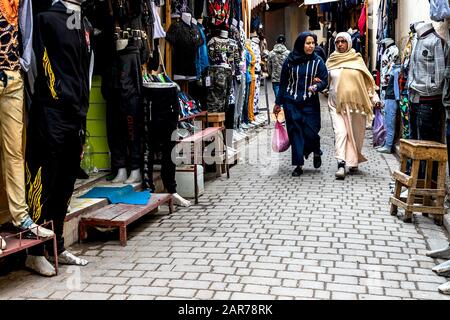 Fes, Marokko - 21.04.2019: Menschen, die in der Straße des Open-Air-Marktbasars in Fez spazieren. Traditionelle nordafrikanische Geschäfte mit handgefertigter Betubung Stockfoto