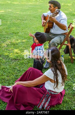 Areco, Argentinien - 22.2018: Ein Gaucho-Gitarrist mit Frauen und Kind bei einem traditionellen Volksfest auf einer Landfarm 112 km nordwestlich von Buen Stockfoto