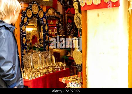 Fes, Marokko - 21.04.2019: Menschen, die in der Straße des Open-Air-Marktbasars in Fez spazieren. Traditionelle nordafrikanische Geschäfte mit handgefertigter Betubung Stockfoto