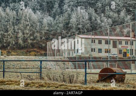 Winter-Fußballfeld mit verfrosteten Bergen im Hintergrund und Toren Stockfoto