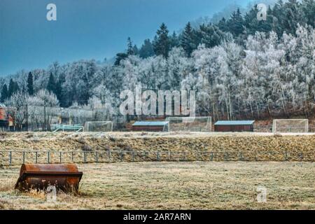 Winter-Fußballfeld mit verfrosteten Bergen im Hintergrund und Toren Stockfoto