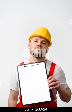 Arbeiter, der die leere Zwischenablage auf weißem Hintergrund hält Stockfoto