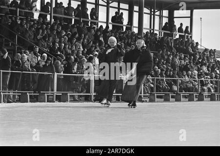 Alte holländische Eisfolklore auf Kunsteisbahn Alkmaar; Reinigung in traditioneller Tracht Datum: 6. März 1976 Ort: Alkmaar, Noord-Holland Schlüsselwörter: Schnee, Folklore, Eis, traditionelles Kostüm Stockfoto