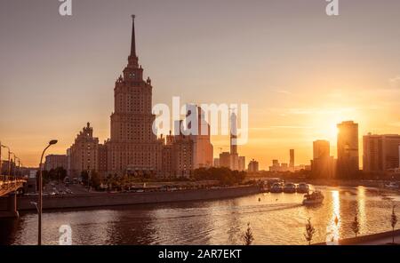 Moskauer Stadtbild bei Sonnenuntergang, Russland. Blick auf die Stadt Moskau mit Radisson Royal Hotel am Moskva Fluss in Sonnenschein. Dieses alte Hochhaus ist ein Landma Stockfoto