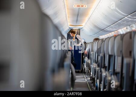 Antalya/TÜRKEI - 24.2020: Stewardess von Airline Sunexpress, fährt mit einem Dienstwagen durch die Passagierkabine. Stockfoto