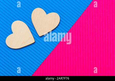 Zwei Herzen auf dem zweifarbigen Wellpappenhintergrund. Blaue und pinke Trendfarben. Abstrakter geometrischer Hintergrund. Hintergrund für den Valentinstag. Stockfoto