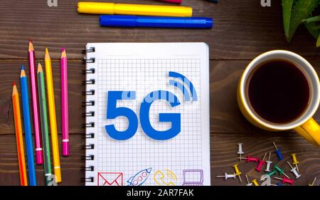 Geschäftsmann links eine Notes 5 G mit Bleistift in Notepad auf dem Desktop. Stockfoto