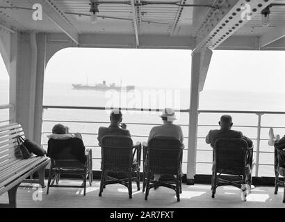 Seereise mit MS Baloeran-Passagieren an Deck; das Frachtschiff ms' Djambi "(1919) von Rotterdamsche Lloyd passiert Anmerkung: Dieses Foto ist Teil einer Reihe von Fotos einer Reise mit der MS Baloeran von de Rotterdam-Lloyd Datum: 1935 Schlüsselwörter: Passagierschiffe, Reisende Stockfoto