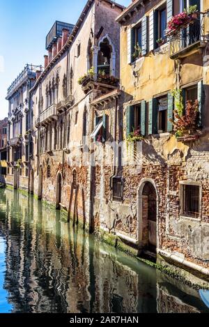 Vintage-Häuser, Venedig, Italien. Blick auf die Fassaden von Wohnhäusern an der alten Straße im Zentrum von Venedig. Romantische Wasserreise durch die Stadt Venedig im Summ Stockfoto