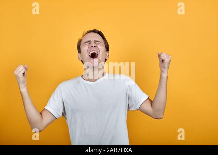 Emotionen verzweifeln Angst Wut. Hebt seine Hände in Wutanschreien mit geöffnetem Mund auf Stockfoto