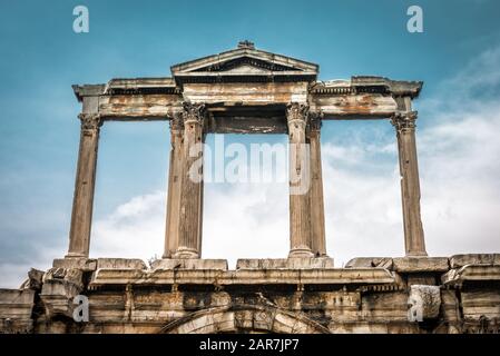 Bogen des Hadrian- oder Hadrianstors, Athen, Griechenland. Detail, oberer Teil auf dem Hintergrund des Himmels. Es ist eines der wichtigsten Wahrzeichen Athens. Vintage-Ansicht von Stockfoto